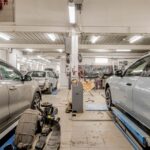 Interior of an automotive repair shop with cars undergoing maintenance and servicing.
